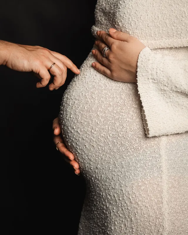 A pregnant woman cradling her belly